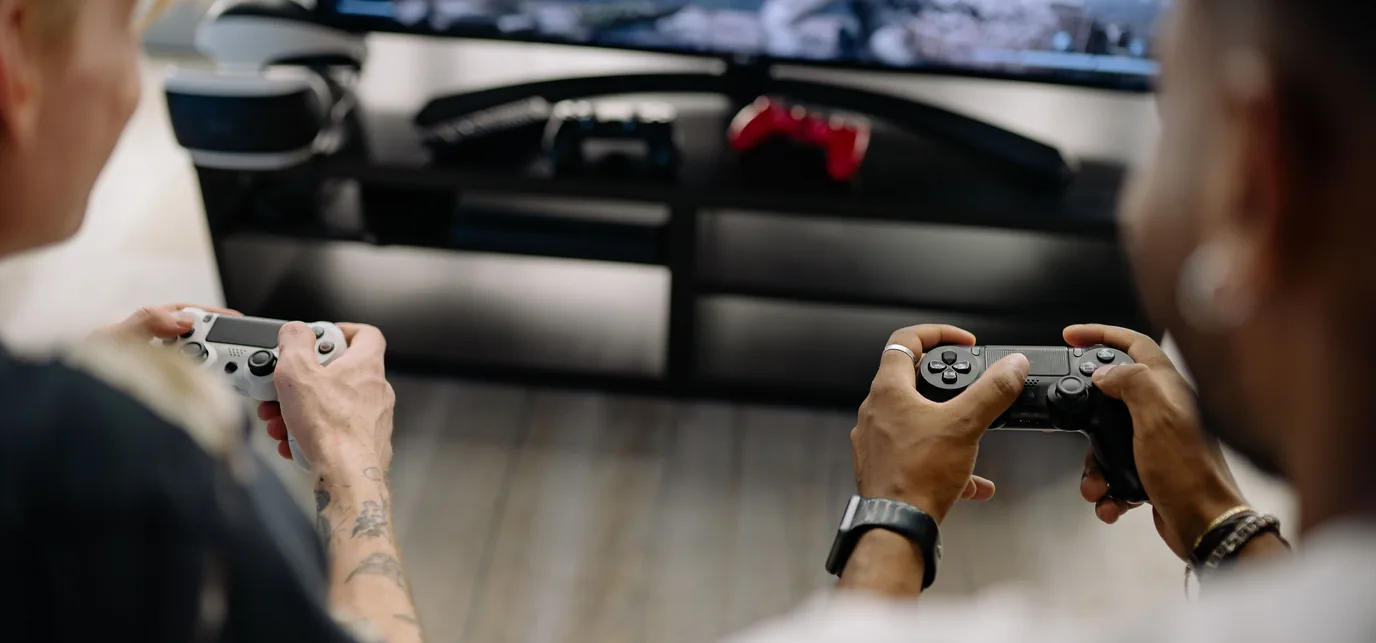 Two friends holding different controllers while playing together