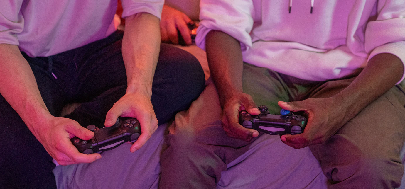 Two friends holding controllers while playing a video game together